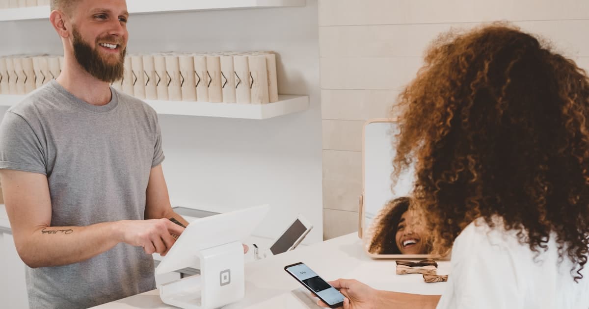 Comerciante atendiendo a un cliente en el mostrador de su negocio